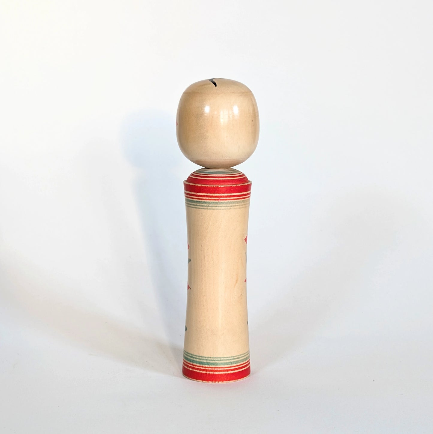 Vue arrière d’une kokeshi Naruko japonaise traditionnelle en bois crée par Sato Kazuo