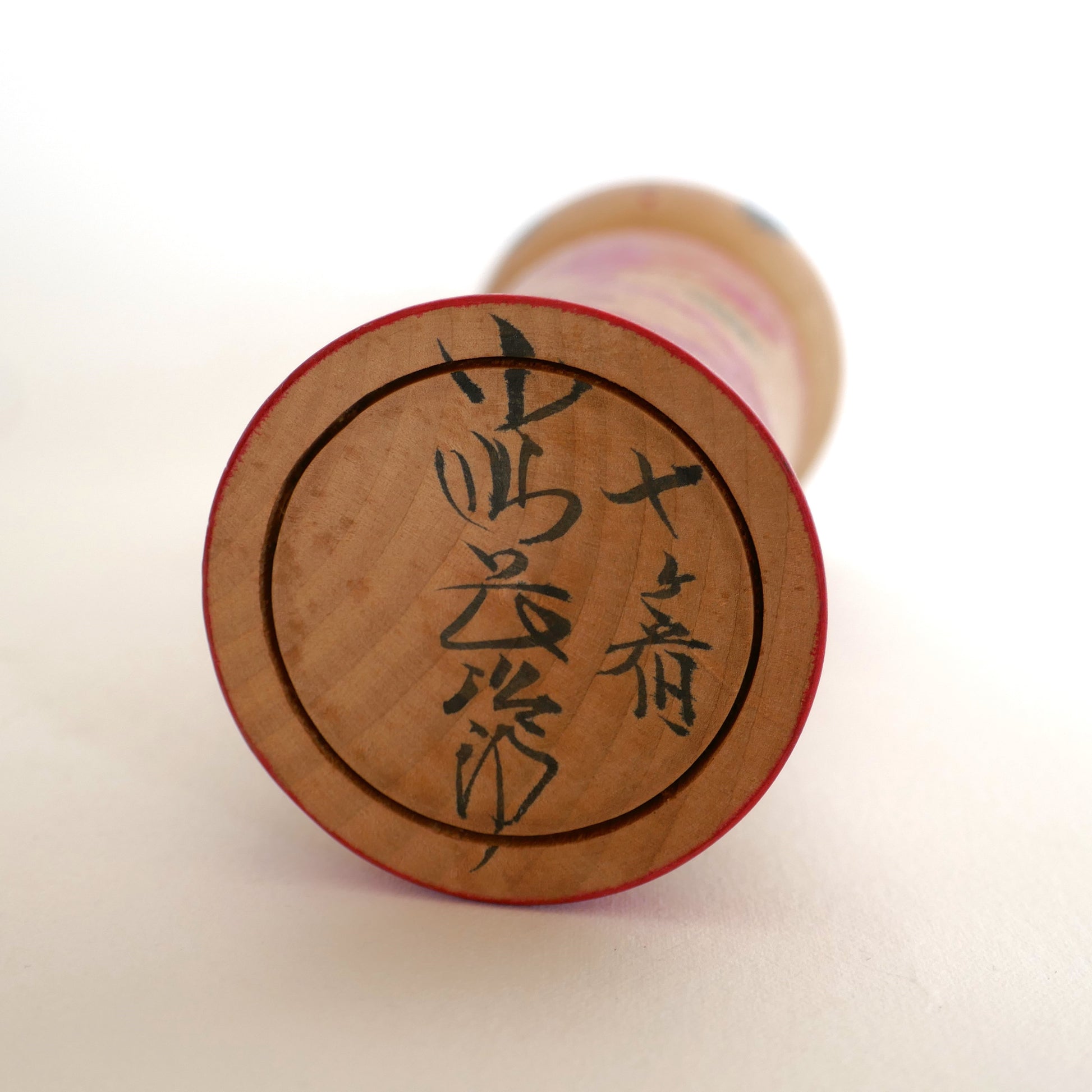 Signature en kanji sous une kokeshi japonaise Naruko, œuvre de l’artisan Kojima Chōjirō, période Shōwa.