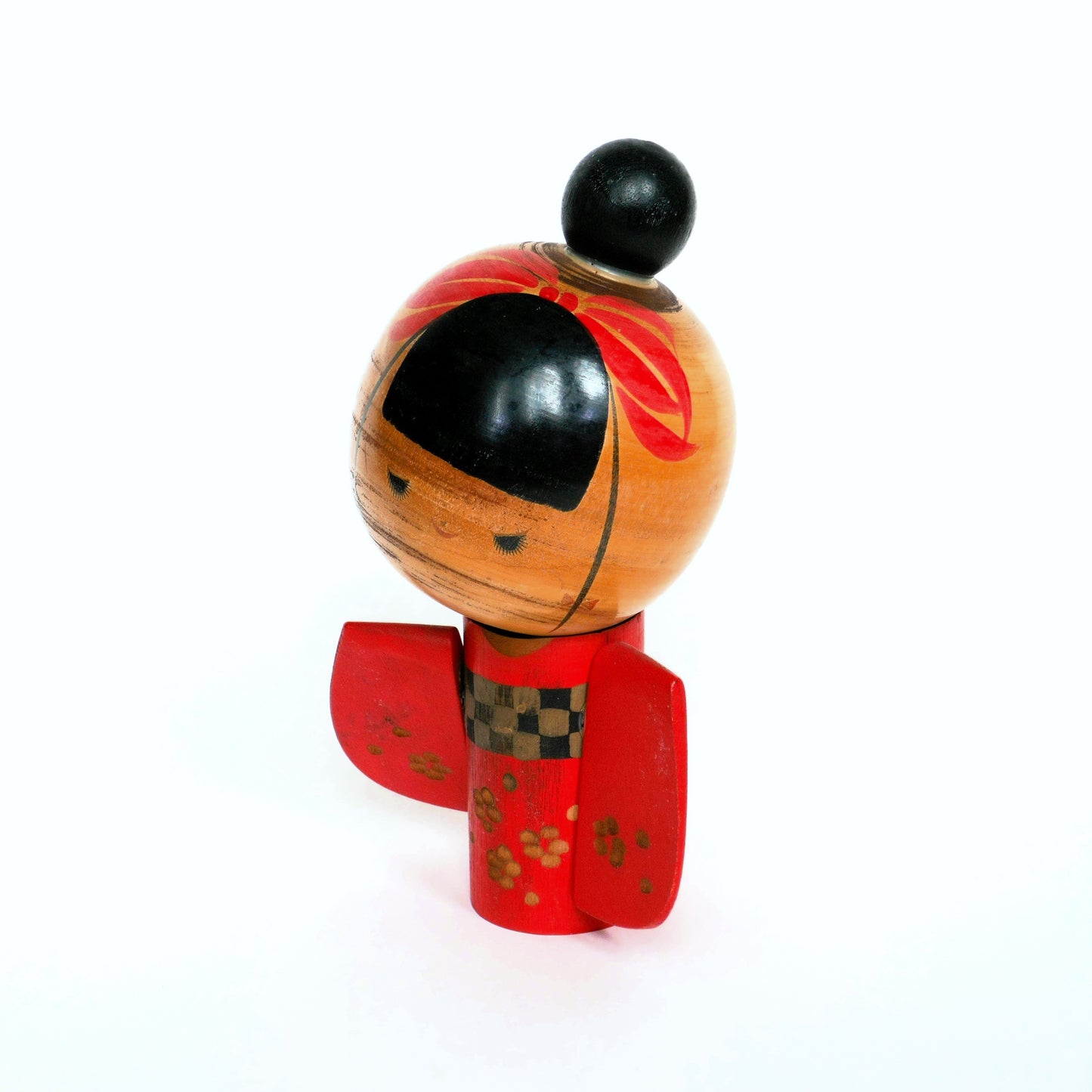 Vue de profil gauche de la kokeshi vintage au kimono rouge et ruban peint.