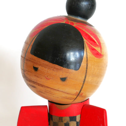 Kokeshi japonaise en bois de Sansaku Sekiguchi photographiée en studio.