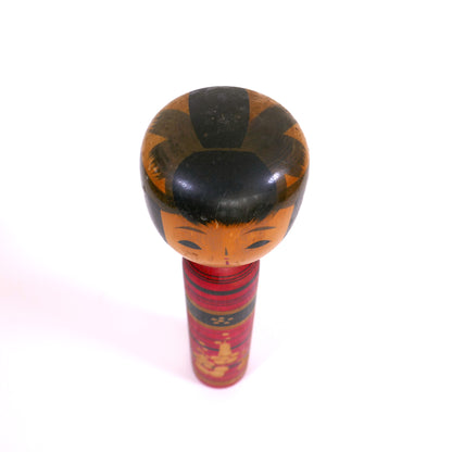 Kokeshi vue du dessus, montrant la coiffure stylisée peinte à la main.