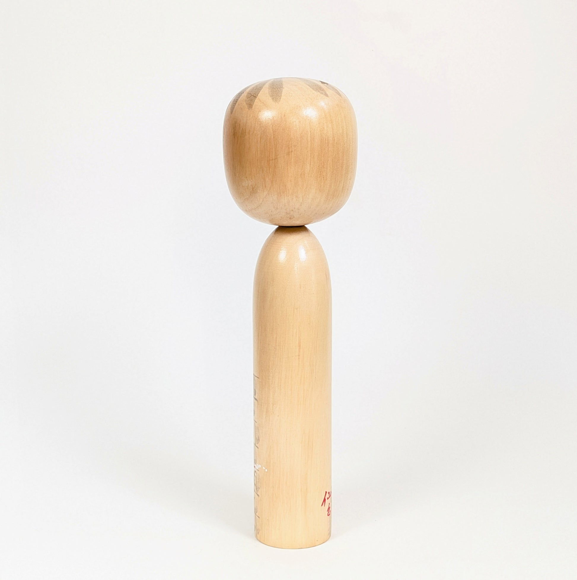 Dos de la kokeshi Shūhō, bois tourné clair et finition brillante, pièce japonaise vintage d’époque Shōwa.