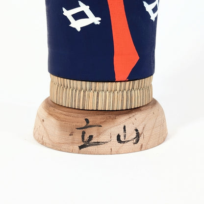 Signature kanji Tateyama 立山 sur base en bois d’une kokeshi japonaise, indiquant son origine montagneuse