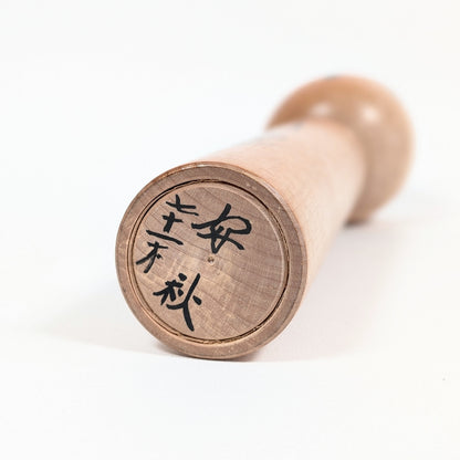 Signature manuscrite de l'artisan Satō Yoshiaki (佐藤好秋), âgé de 71 ans, sous la base d'une kokeshi japonaise ancienne.
