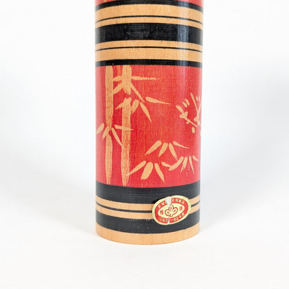 Détail de l’étiquette d’origine sur une kokeshi sosaku japonaise rouge décor bambou