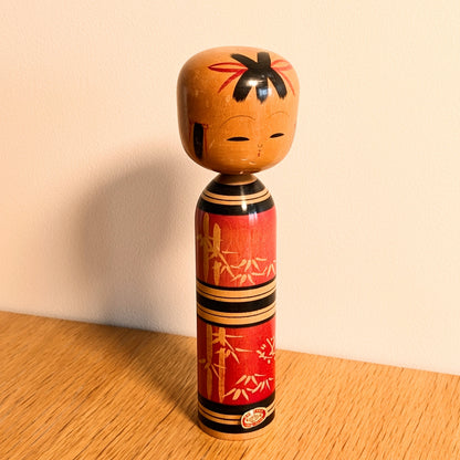 Kokeshi créative sosaku par Kawamura Shōji, poupée japonaise en bois rouge décorée de motifs de bambou
