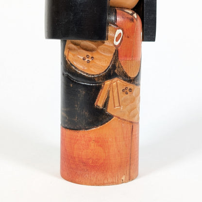 Détail latéral d’une kokeshi sosaku avec motifs japonais sculptés dans le bois