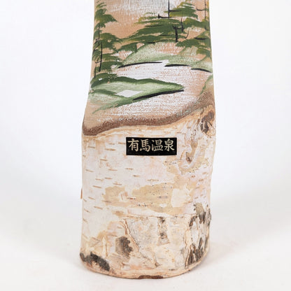 Détail de l’étiquette 有馬温泉 Arima Onsen sur une kokeshi souvenir japonaise en bois avec décor peint