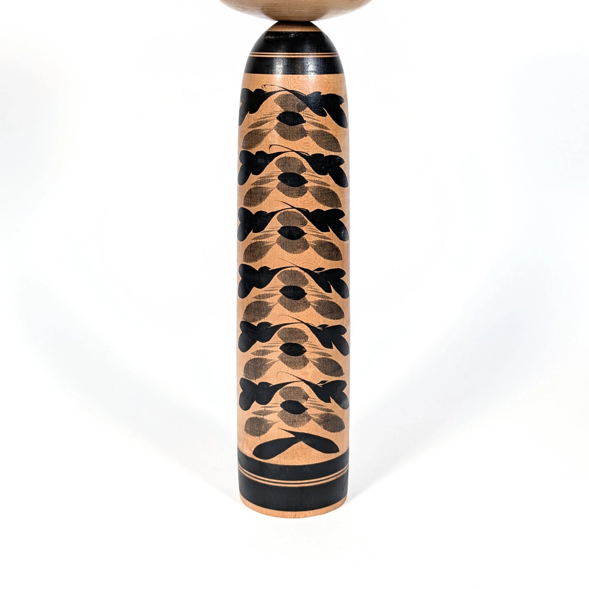 Motifs de chrysanthèmes kasane giku superposés noirs et gris sur le corps d’une grande kokeshi Togatta, décoration florale japonaise traditionnelle