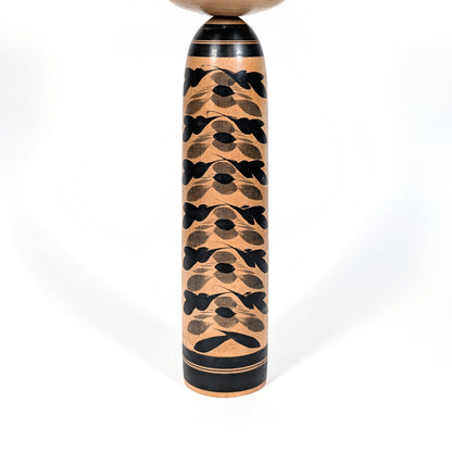 Motifs de chrysanthèmes kasane giku superposés noirs et gris sur le corps d’une grande kokeshi Togatta, décoration florale japonaise traditionnelle