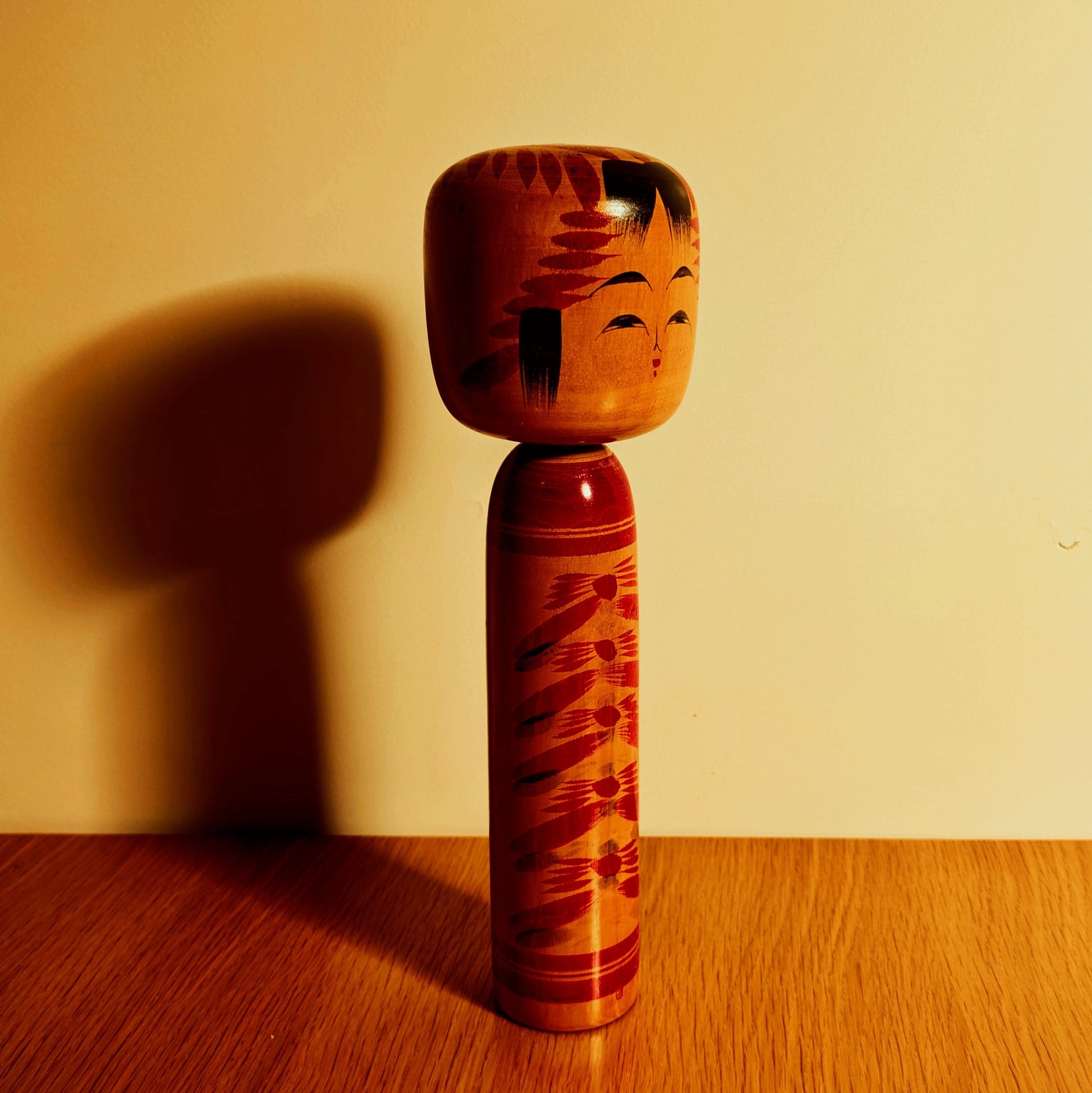 Kokeshi japonaise Togatta signée Fuko photographiée en lumière chaude, grande poupée traditionnelle en bois à motifs kasane giku