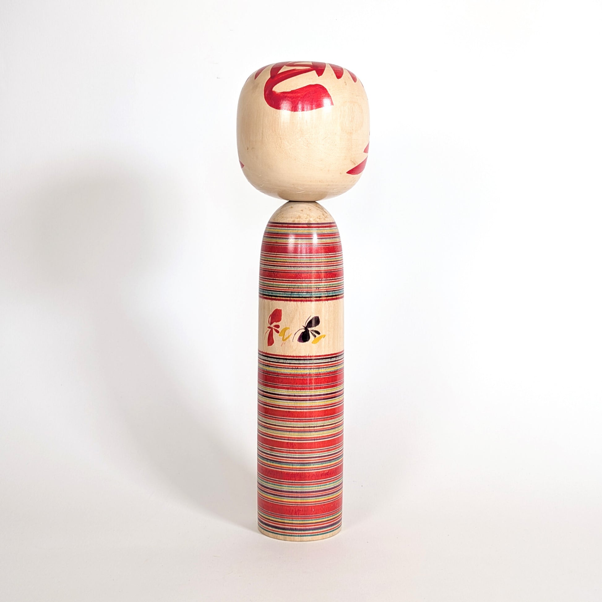 Motif papillons cho sur kokeshi Togatta Sakuta Koichi, symbole traditionnel japonais en bois
