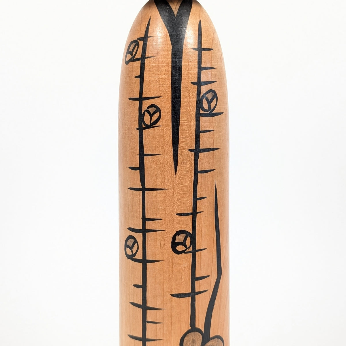 Détail des branches et bourgeons de prunier stylisés sur une kokeshi traditionnelle Tōgatta de Satō Yoshiaki.