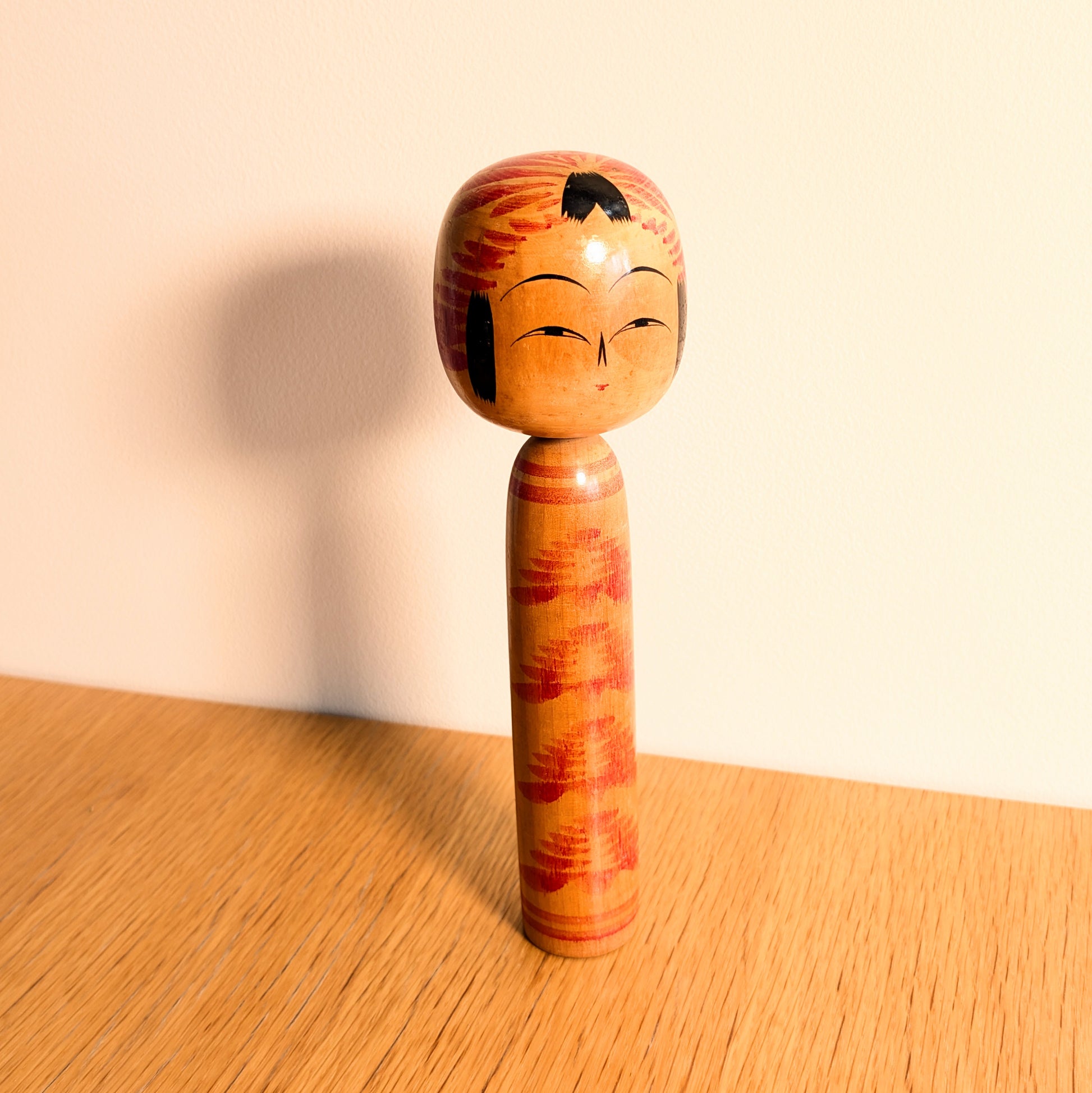 Kokeshi Togatta par Ōnuma Shōji, poupée japonaise traditionnelle en bois avec motifs tegara sur la tête et kasanegiku sur le corps.