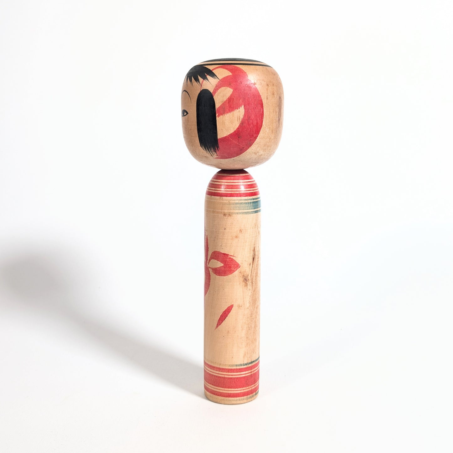 Kokeshi traditionnelle japonaise de l’artisan Katō Yasuaki, style Tsuchiyu de Fukushima avec motif floral iris stylisé.