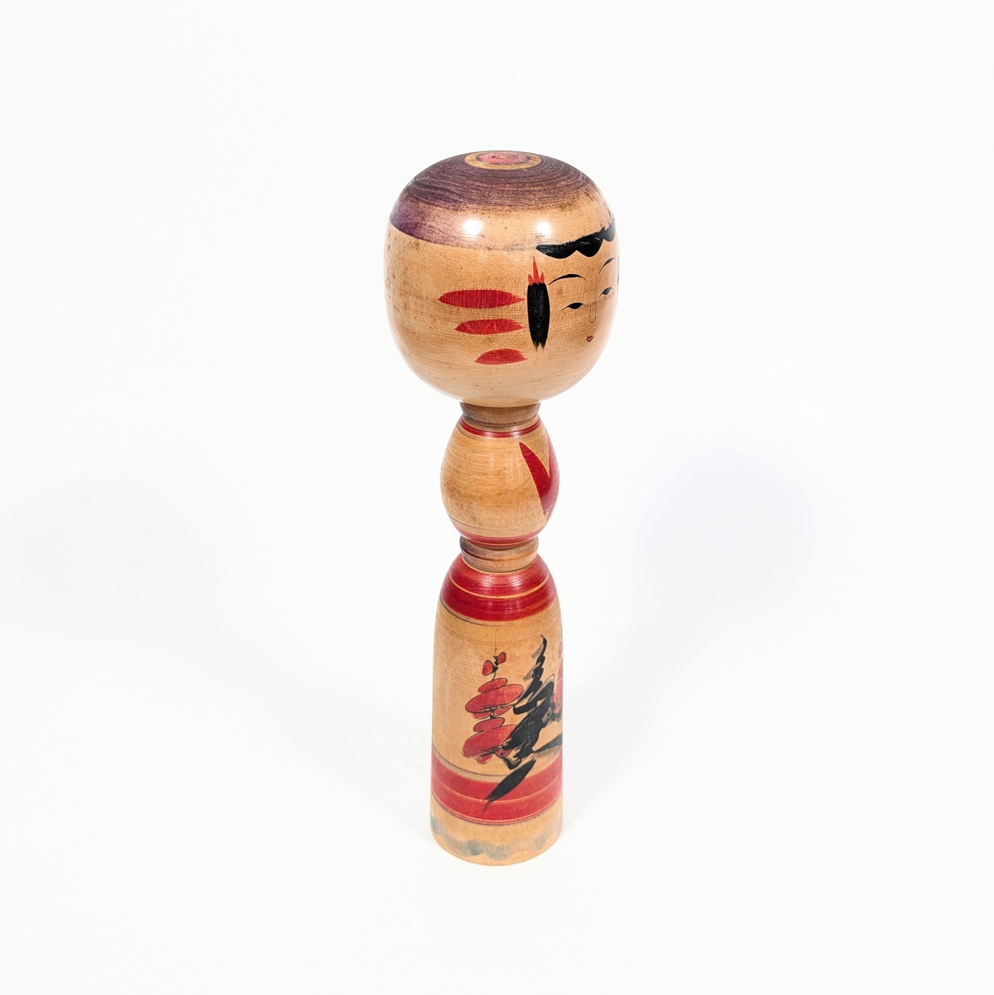 Kokeshi traditionnelle de Miyagi vue de trois quarts, poupée japonaise en bois tourné ornée de fleurs de prunier