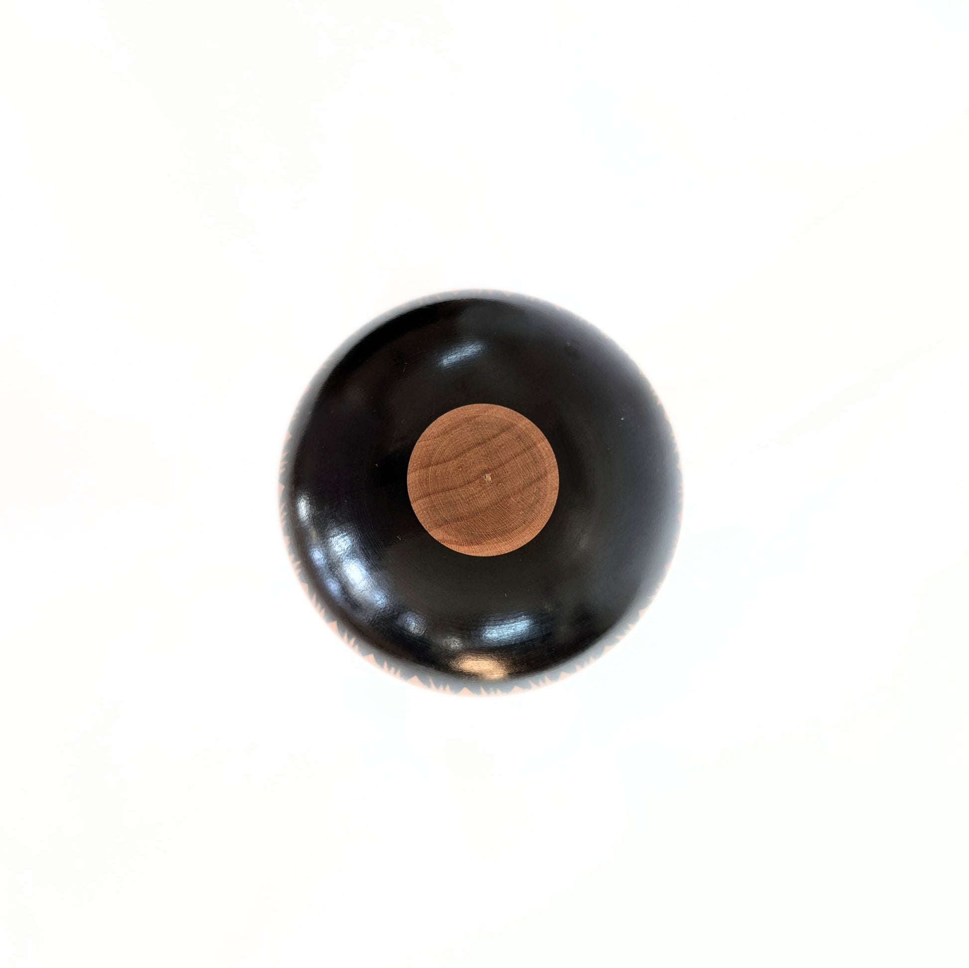 Vue du dessus d'une kokeshi artisanale japonaise Oshin de Mamoru Izu en bois laqué noir