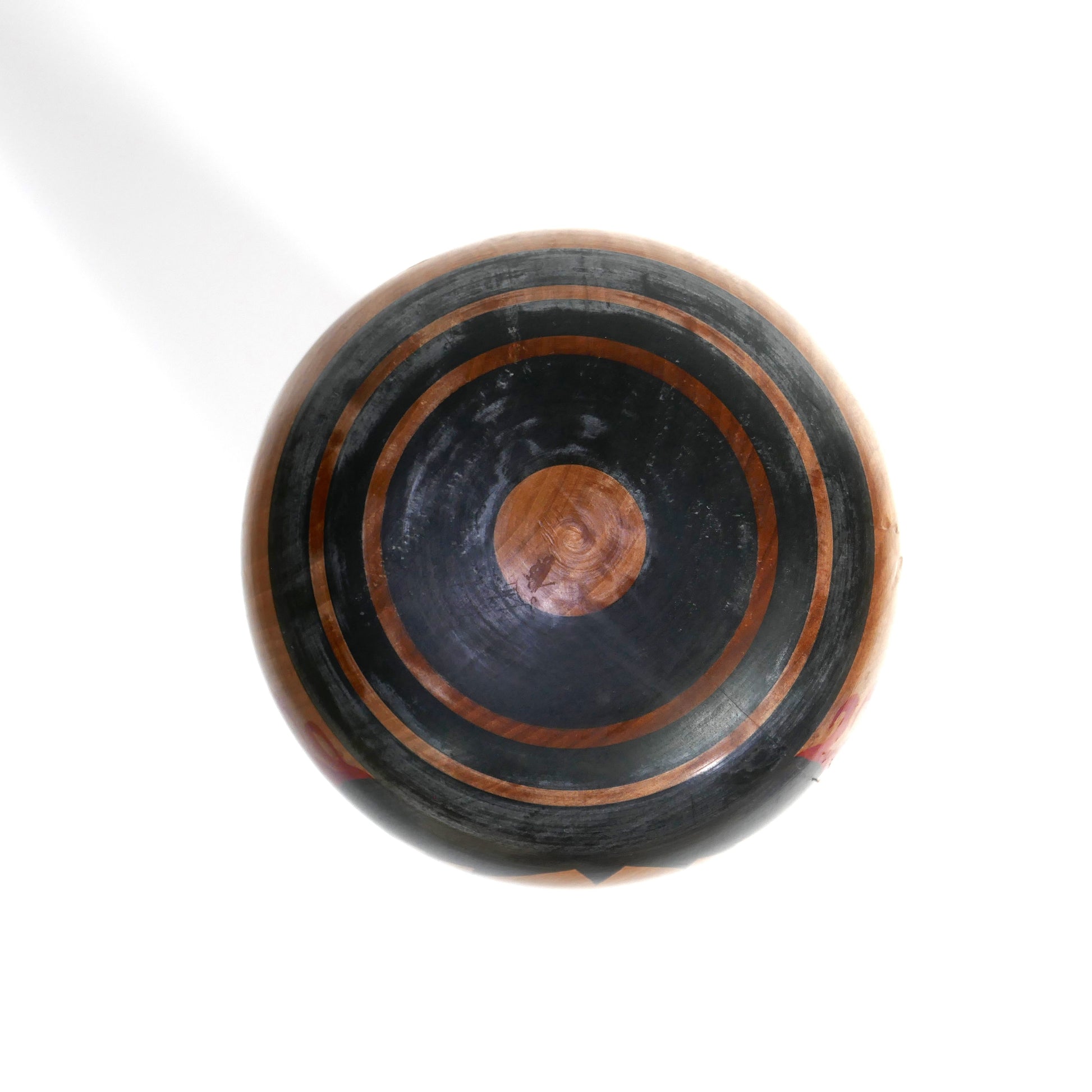 Vue du dessus d'une kokeshi Tsuchiyu ancienne par Abe Kazue, décoration circulaire et Janome peints à la main sur la tête en bois.