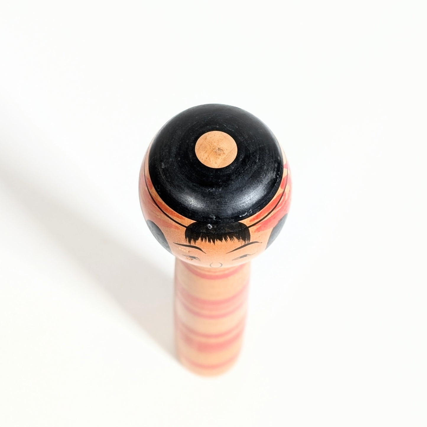 Sommet de tête d’une kokeshi Tsuchiyu Chuzo Watanabe avec coiffure traditionnelle japonaise en motif janome, art mingei