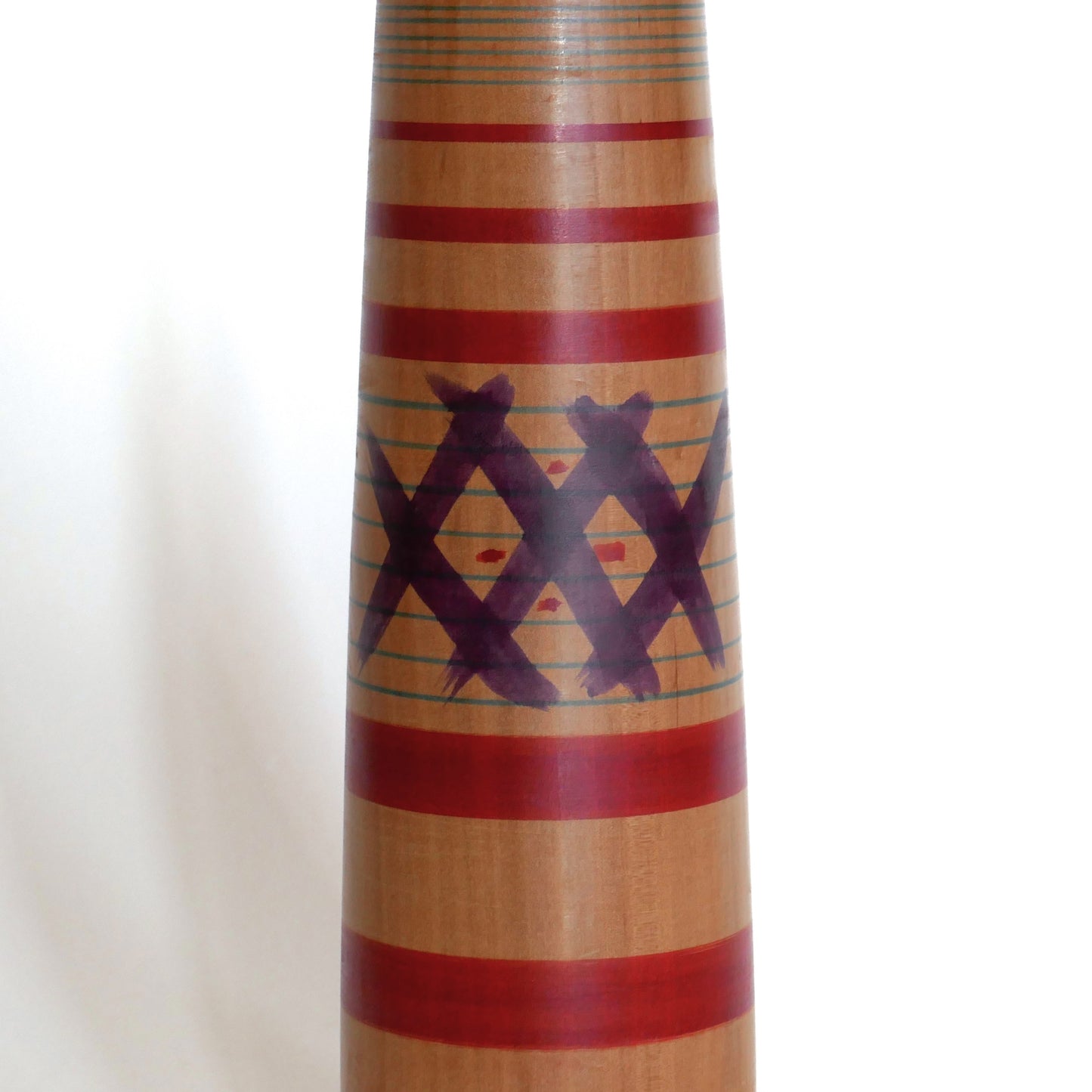 Détail du motif peint sur le corps d’une kokeshi japonaise ancienne, artisanat en bois du style Tsuchiyu.