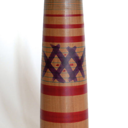 Détail du motif peint sur le corps d’une kokeshi japonaise ancienne, artisanat en bois du style Tsuchiyu.