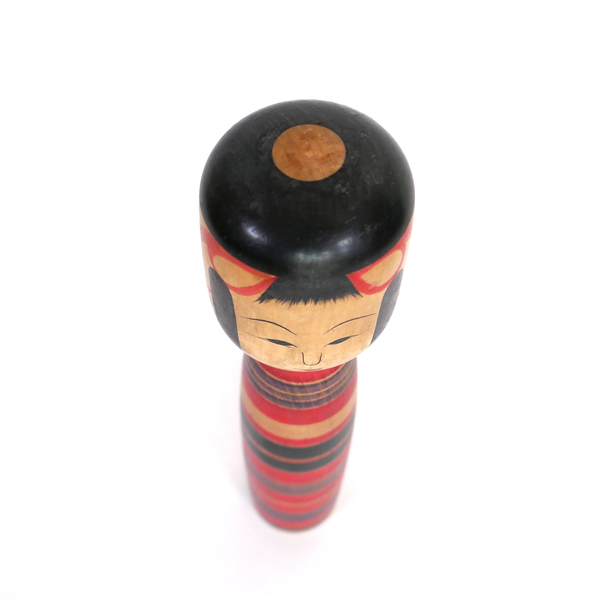Vue du dessus d'une kokeshi japonaise ancienne coiffée de noir, artisan Sato Sashima