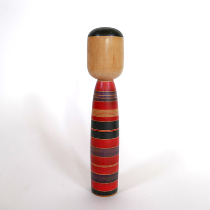 Vue arrière d'une kokeshi japonaise artisanale style Tsuchiyu rouge, violet et noir