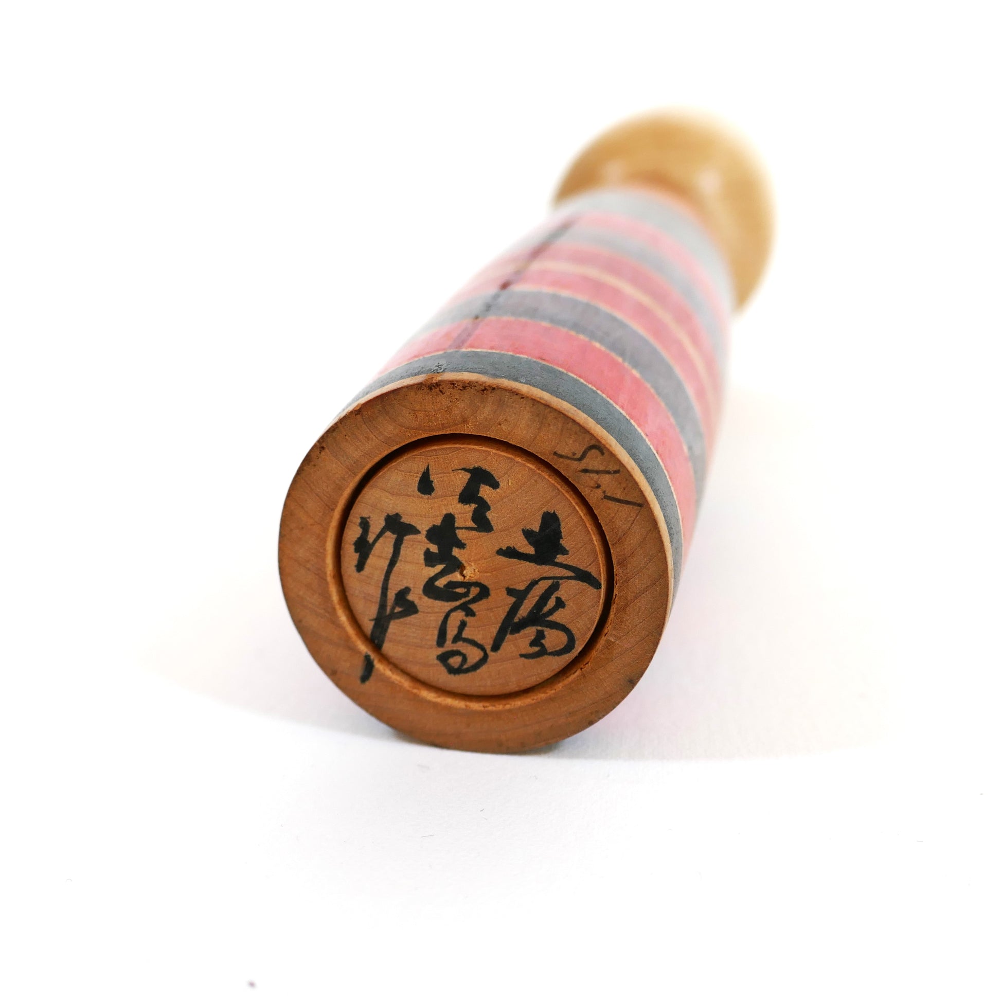Signature en japonais sous la base d'une kokeshi ancienne style Tsuchiyu signée Sato Sashima