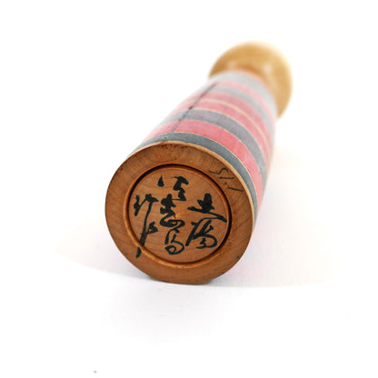 Signature en japonais sous la base d'une kokeshi ancienne style Tsuchiyu signée Sato Sashima