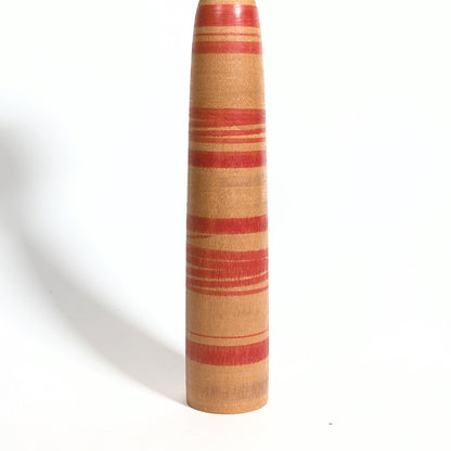 Détail du corps rayé rouge d’une kokeshi Tsuchiyu Watanabe Chuzo en bois massif tourné, artisanat japonais