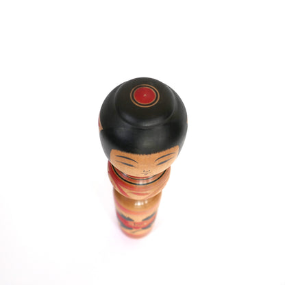 Vue du dessus d'une poupée Kokeshi Tsugaru peinte à la main avec coiffe noire