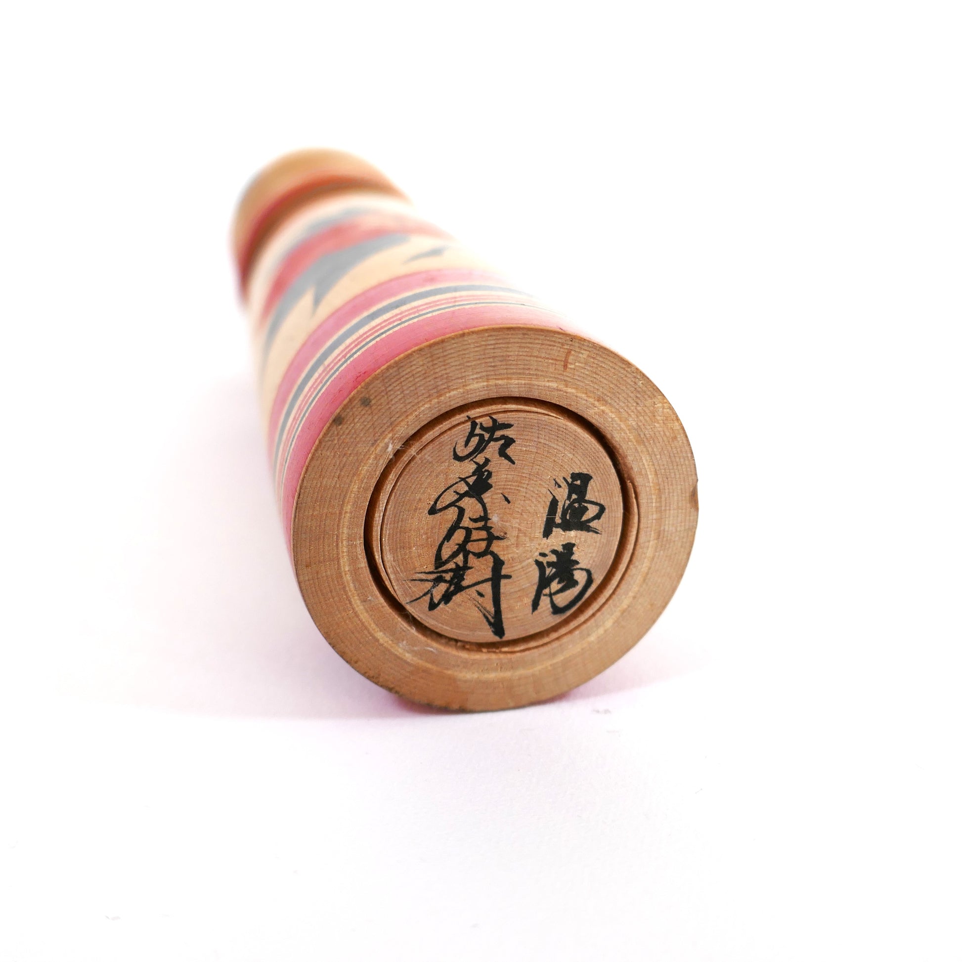 Signature de l’artisan japonais Sato Yoshiki sous une Kokeshi Tsugaru en bois