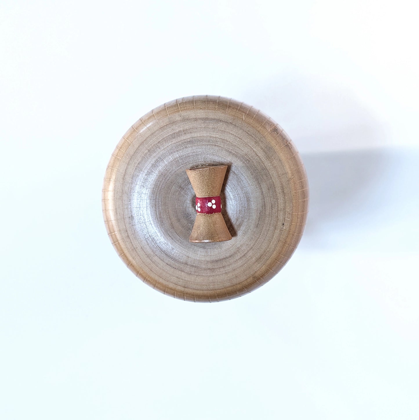 Détail du chignon décoratif sur la tête de la kokeshi Ueda Izumi.