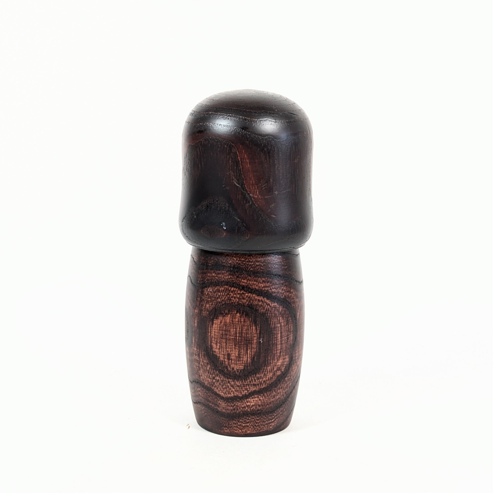 Dos d’une kokeshi vintage Usaburo Shunsai en bois foncé avec veinage apparent