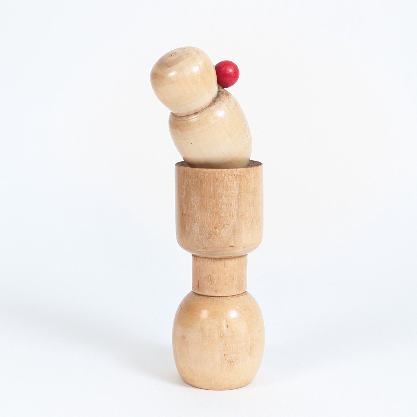 Vue arrière d’une kokeshi vintage japonaise d’Ishida Tomio montrant le bois tourné et la silhouette sculpturale.