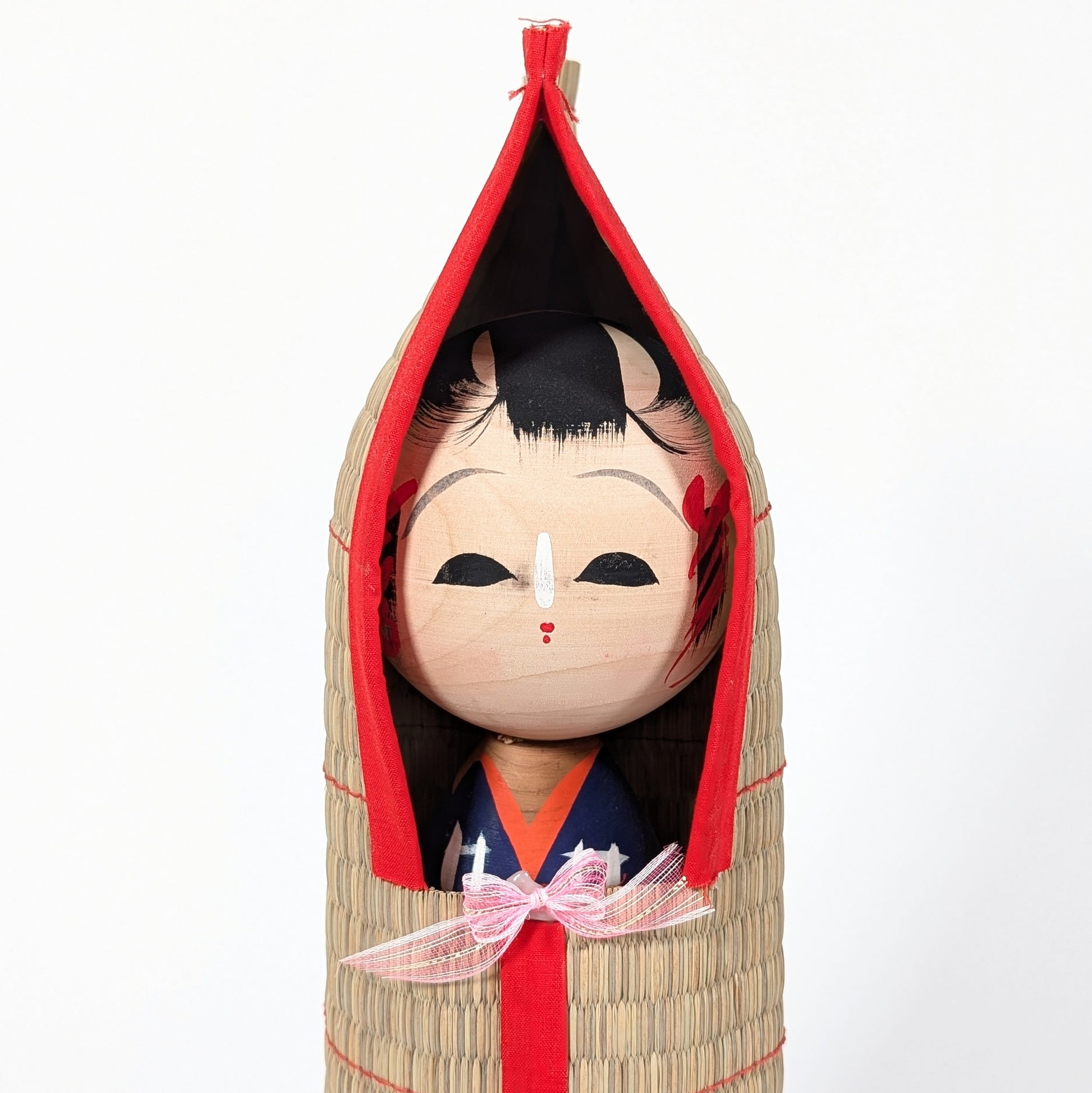 Détail du visage peint à la main d’une kokeshi japonaise, expression douce et artisanat traditionnel en bois
