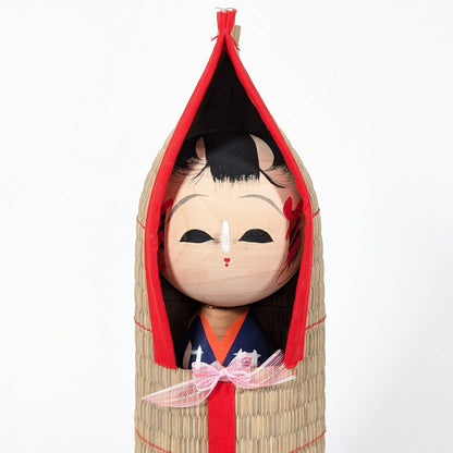 Détail du visage peint à la main d’une kokeshi japonaise, expression douce et artisanat traditionnel en bois