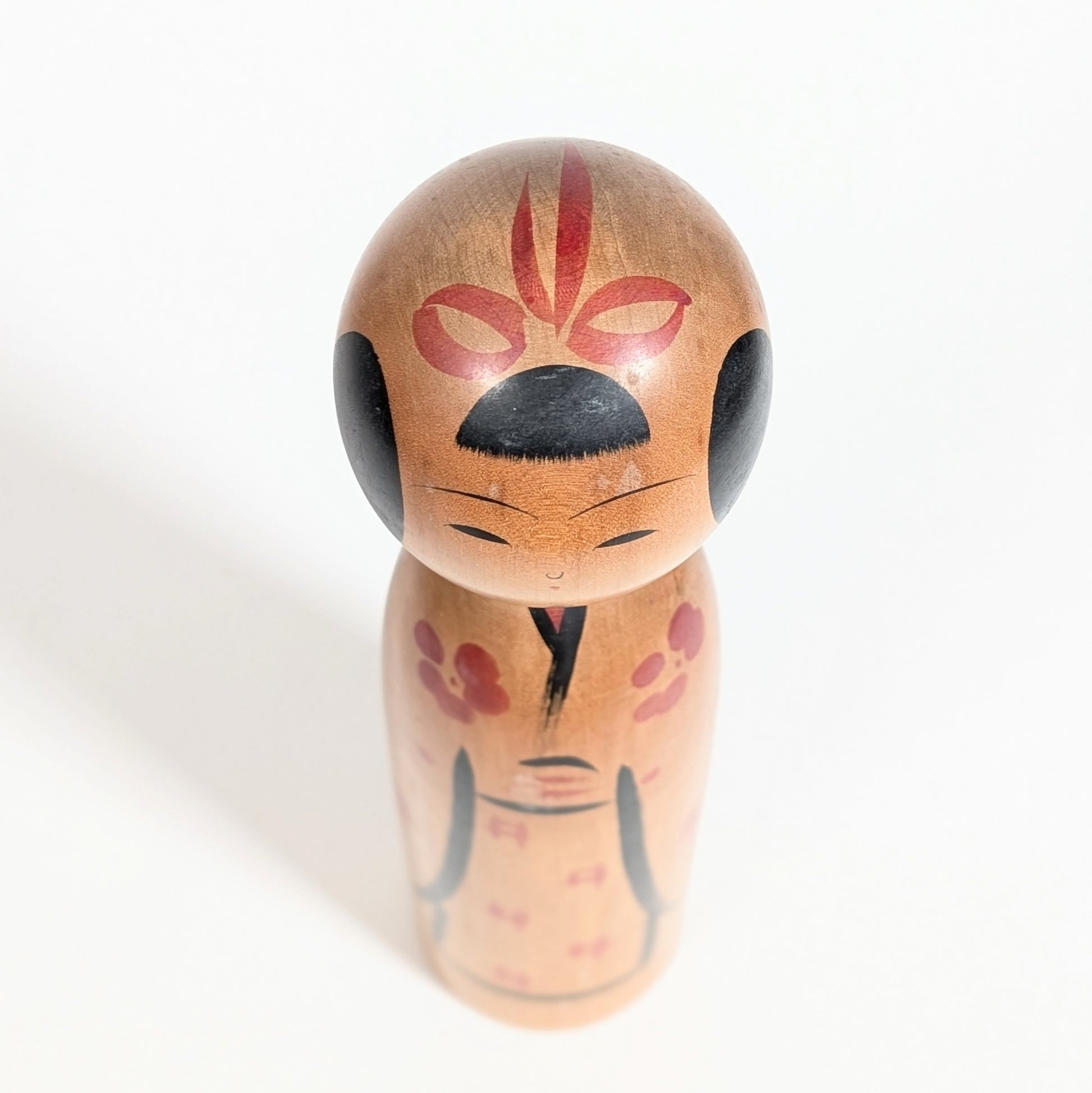 Visage minimaliste de kokeshi japonaise avec coiffure noire et expression douce artisanat traditionnel