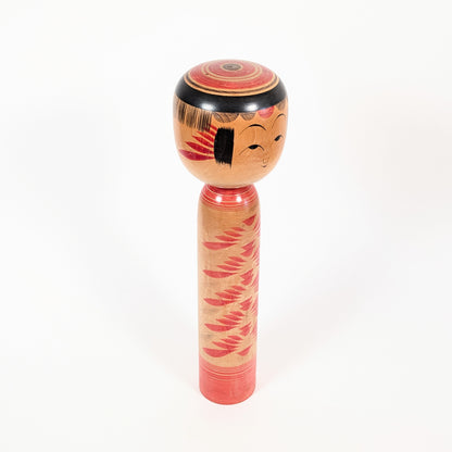 Kokeshi Yajirō par Kamata Kōichi vue de trois quarts droit, montrant la coiffure janome et le décor floral peint au tour.