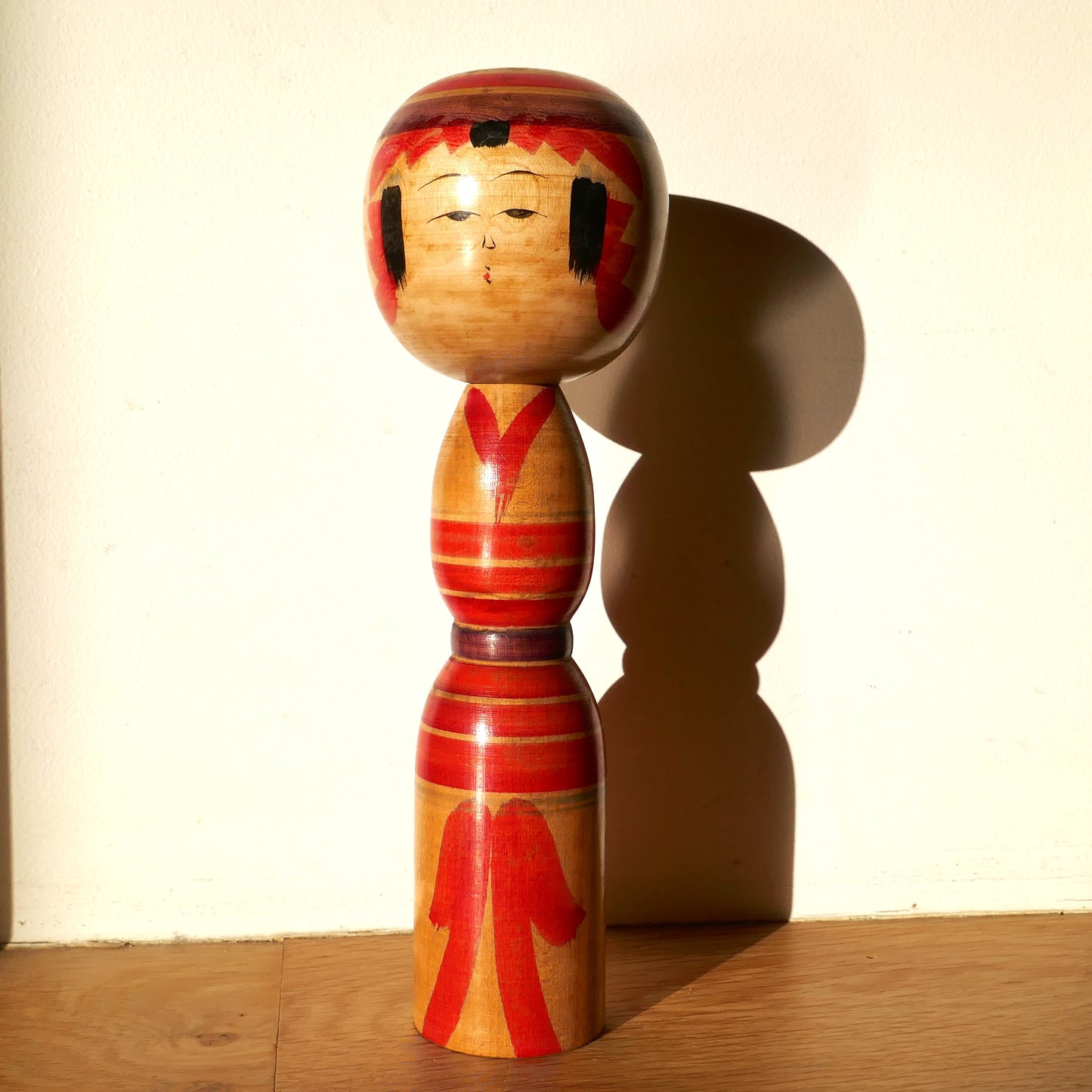 Kokeshi Yajirō ancienne signée Niiyama Fukuo sous une lumière naturelle avec ombre visible