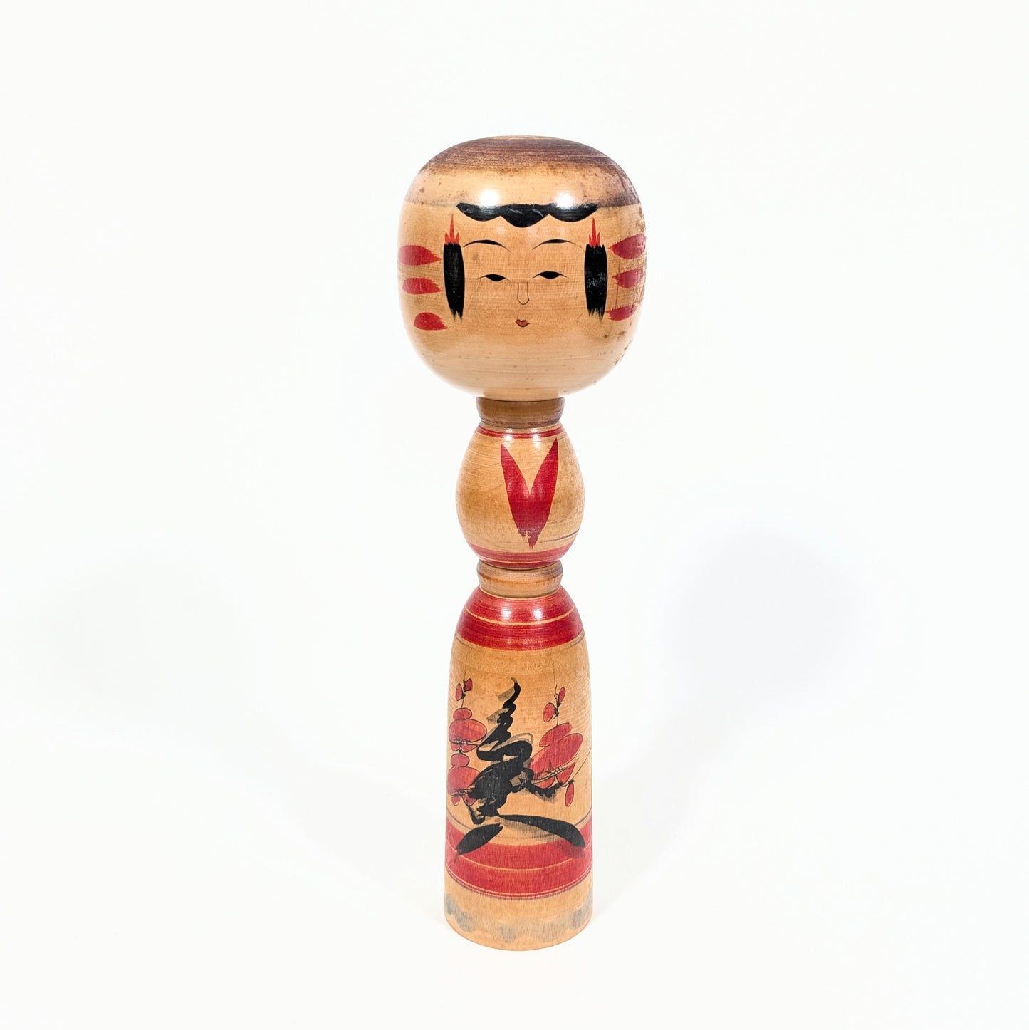 Poupée japonaise Kokeshi Yajirō d’Ogura Katsushi vue de face, visage peint à la main et motif de branches fleuries de ume rouges et noires, 30,5 cm