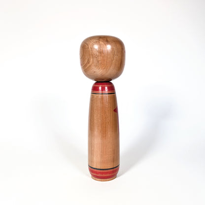 Vue de dos d’une kokeshi japonaise ancienne en bois naturel, école Yamagata, poupée japonaise artisanale période Showa
