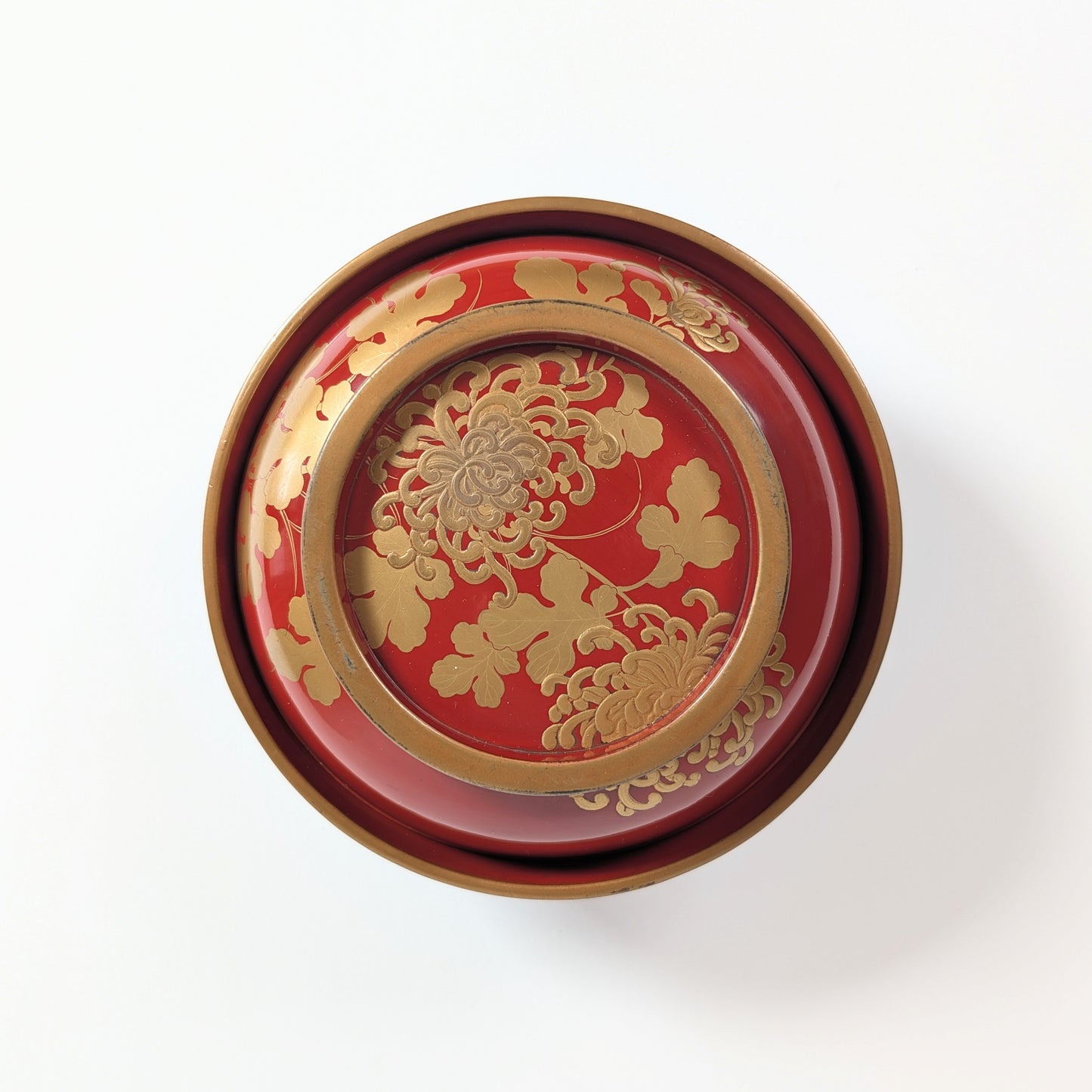 Vue supérieure du décor kikusui associant chrysanthèmes kiku et eau courante sur un bol japonais en laque urushi.
