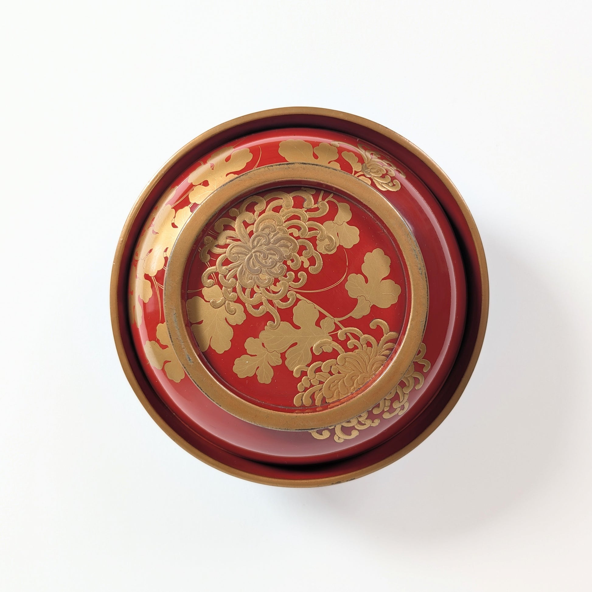 Vue supérieure du décor kikusui associant chrysanthèmes kiku et eau courante sur un bol japonais en laque urushi.