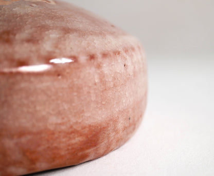 Macro de l’émail rose craquelé kanyū sur bol matcha raku, texture artisanale wabi-sabi