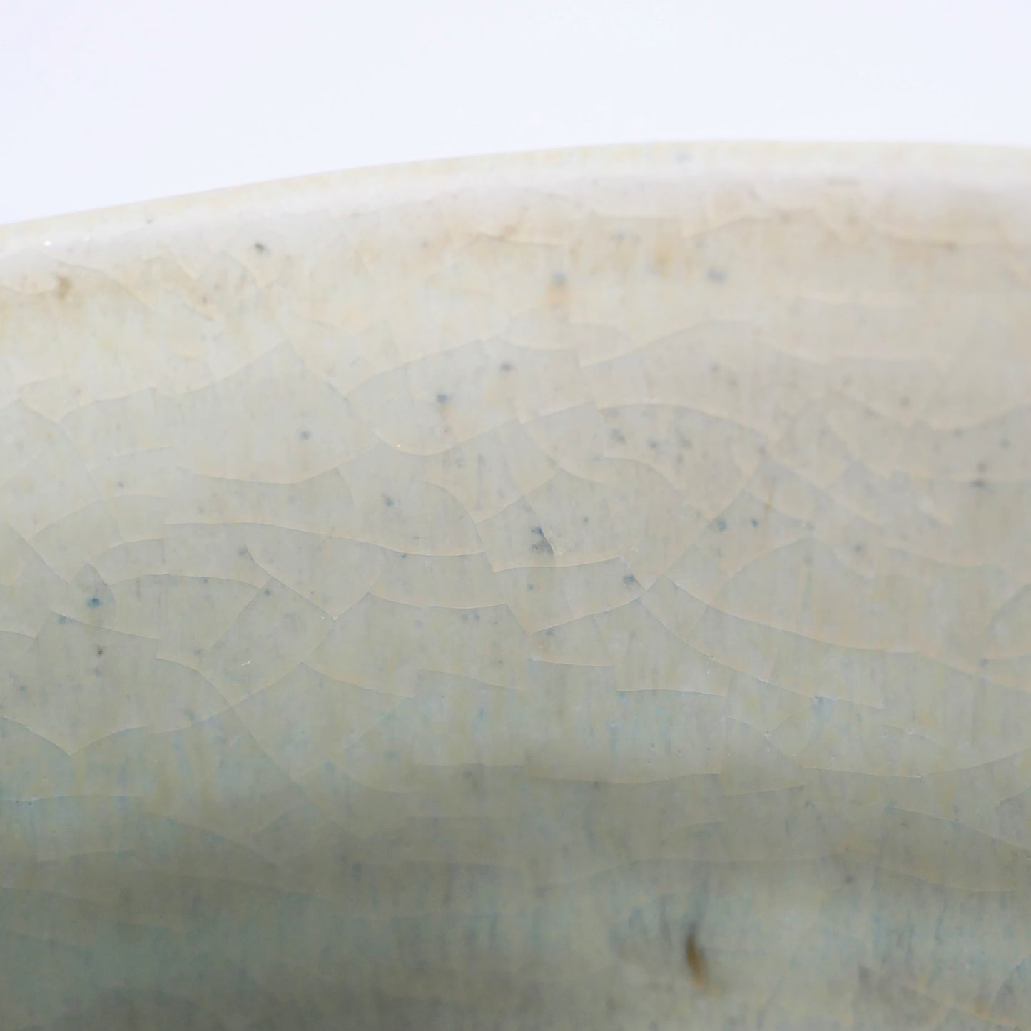 Macro de la glaçure craquelée d’un chawan japonais Akahada-yaki, émail vert d’eau et texture wabi-sabi
