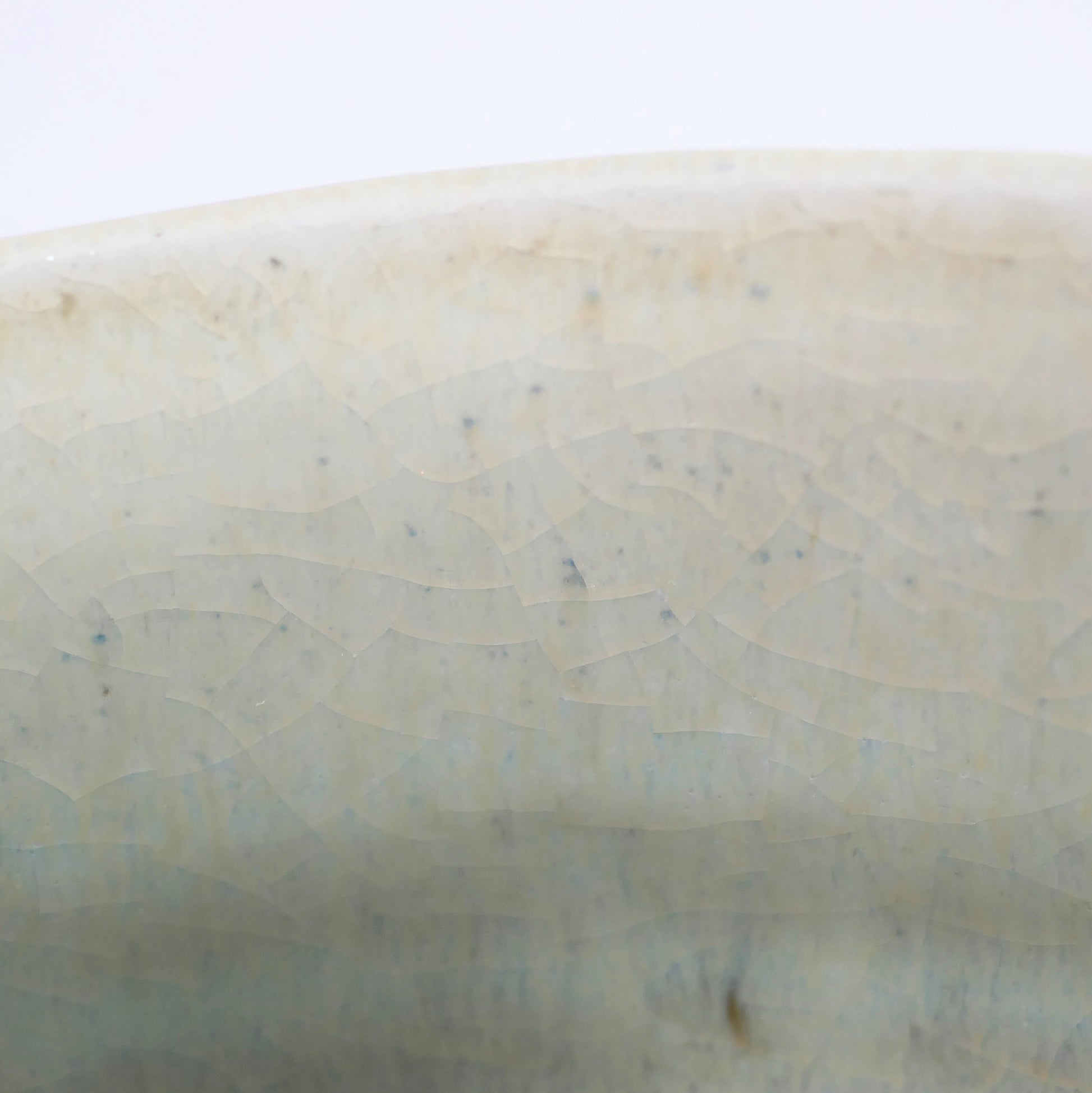 Macro de la glaçure craquelée d’un chawan japonais Akahada-yaki, émail vert d’eau et texture wabi-sabi