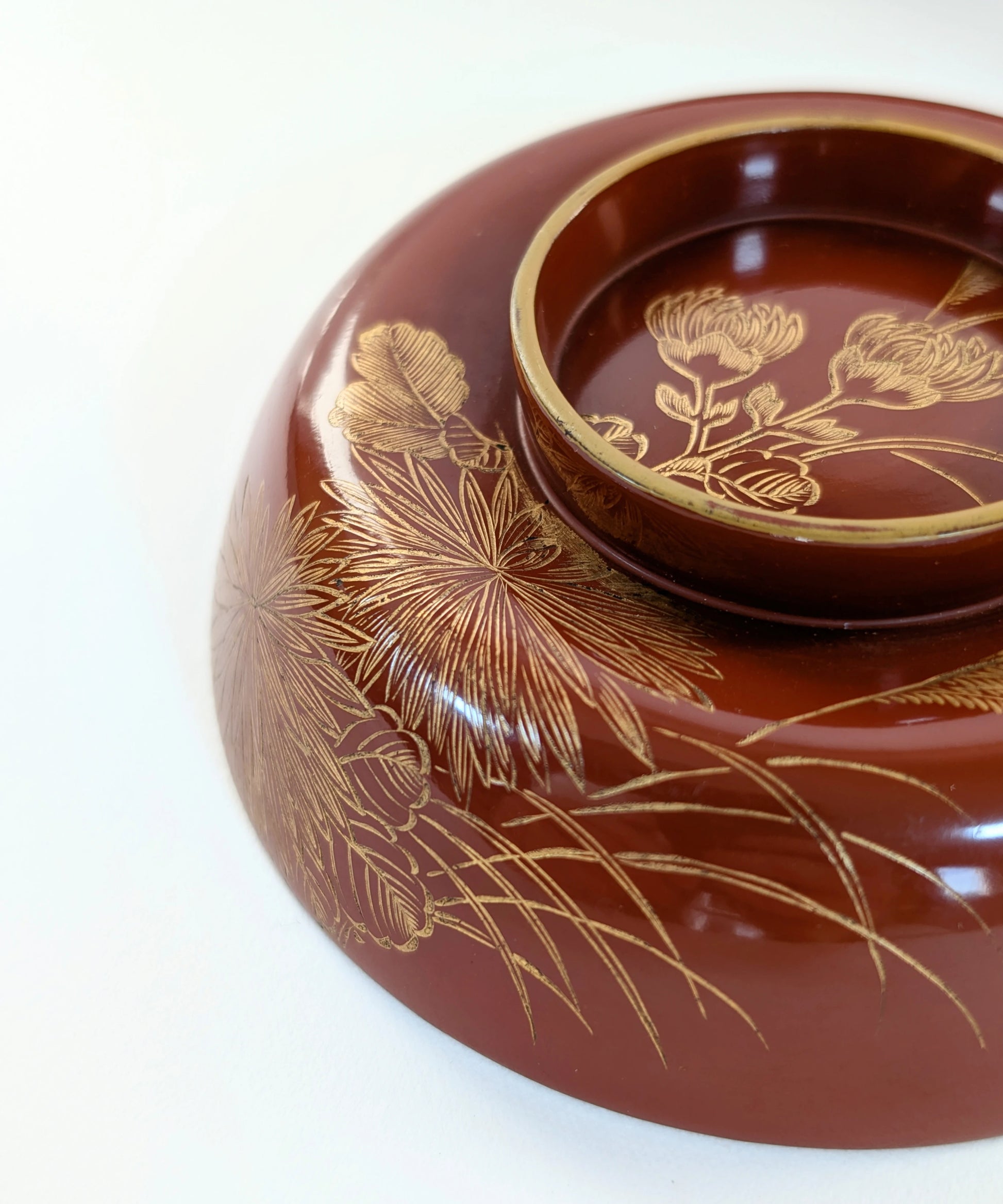 Vue rapprochée d’un chrysanthème  dessiné en maki-e sur laque urushi.