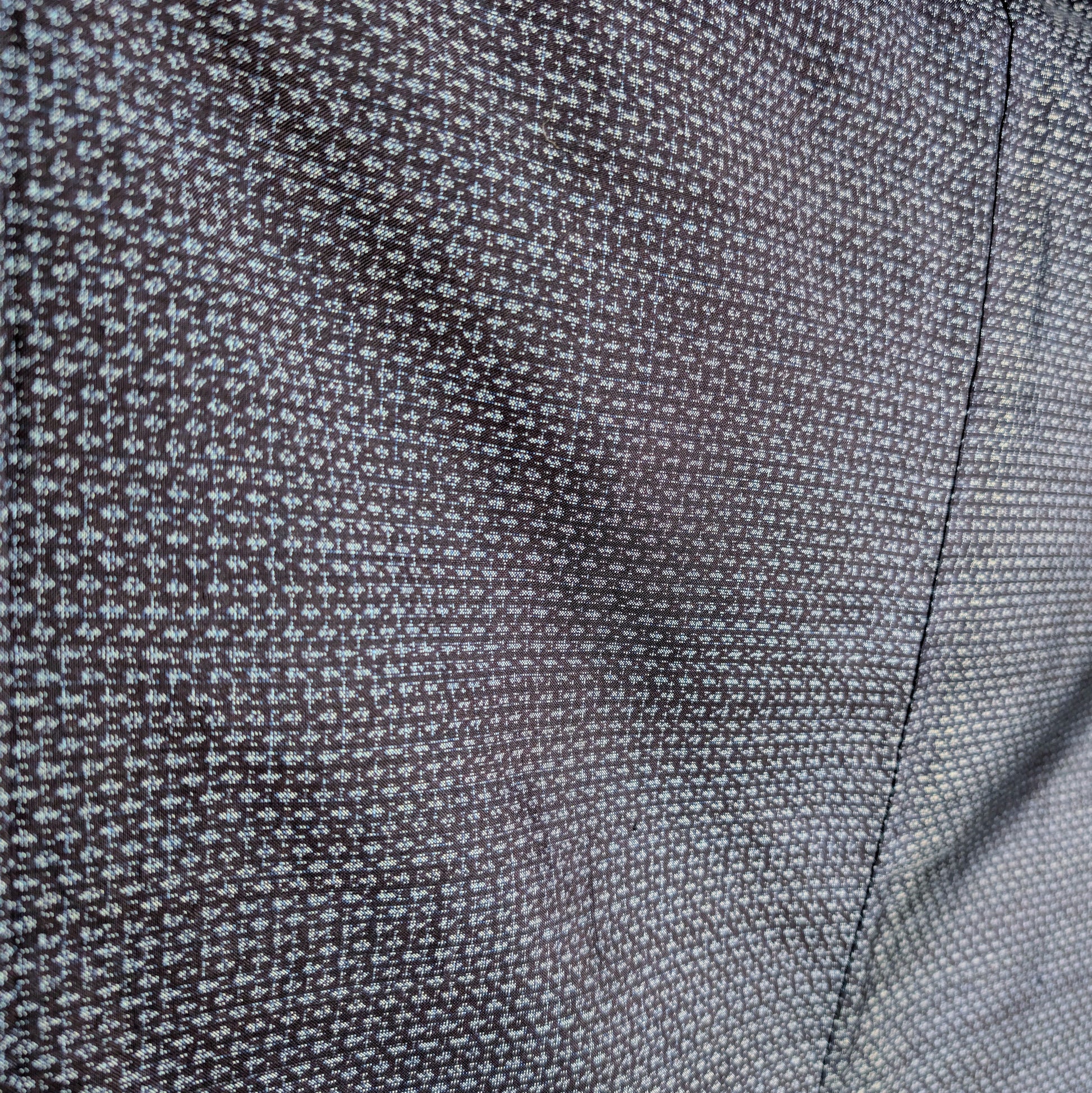 Gros plan sur le tissage Ōshima Tsumugi bleu à motif kasuri d’un haori homme en soie japonaise