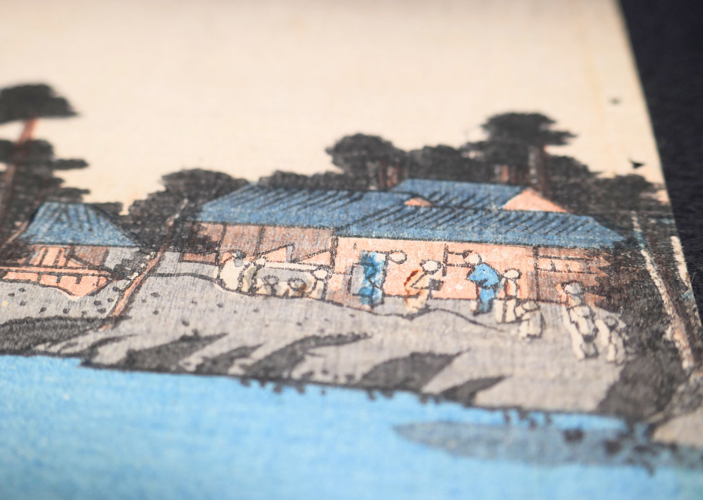 Détail du paysage au bord de l’eau avec maisons, arbres et silhouettes, extrait d’une estampe japonaise ancienne de Kunisada Toyokuni III.